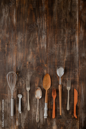 display of variety of vintage cutlery on dark wooden board table with space for text photo