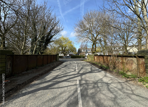 Greenfield Lane, on a cold winters day, with bare old trees, metal fencing, and distant houses in, Bierley, Tong, UK photo