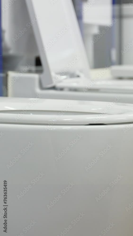Row of toilets put up for sale in a plumbing store. Vertical video Row of toilets put up for sale in a plumbing store. Vertical video