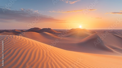 The first light of dawn spreads a golden hue across the desert  illuminating the gentle curves of the sand dunes with a warm  soft glow.
