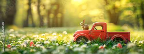 Red toy retro car with easter rabbit on the roof on fairytale spring field. Car with bunny on green natural blurred background. Greeting card or festive banner with copy space