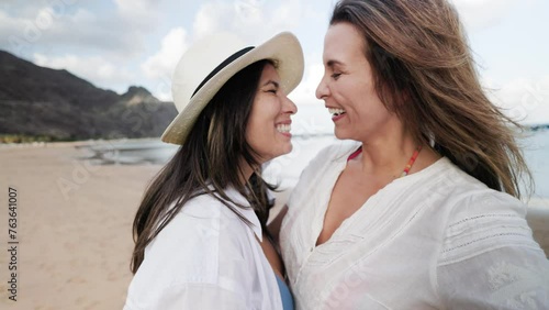 Gay lesbian couple smiling at beach side during travel vacations. Joyful lifestyle and LGBT relationships