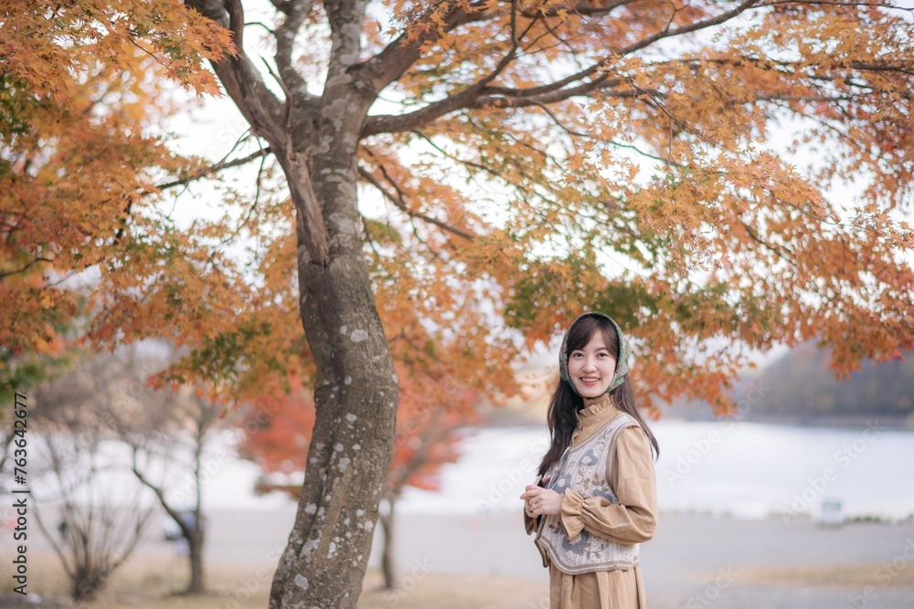 Asian woman in casual dress enjoys Japan's beauty, walking amid vibrant foliage. A cheerful holiday portrait capturing the essence of nature, fashion, and a journey. Asian woman in casual dress enjoys Japan's beauty, walking amid vibrant foliage. A cheerful holiday portrait capturing the essence of nature, fashion, and a journey.