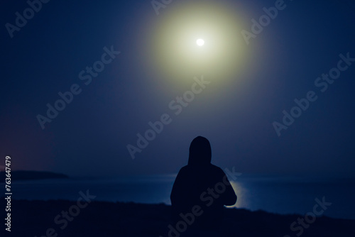sylwetka osoby przy świetle księżyva photo