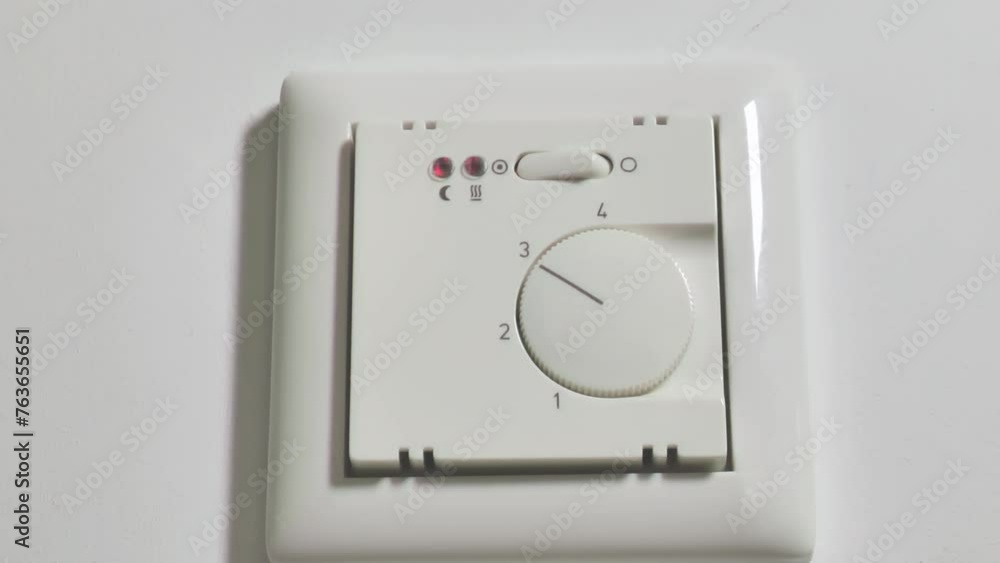 Warm floors switch.Heated floor control button. Control of the heating system in the house. Heating the house with warm floors.Hand turns on the floor heating. Heating control in the house. Warm floors switch.Heated floor control button. Control of the heating system in the house. Heating the house with warm floors.Hand turns on the floor heating. Heating control in the house.
