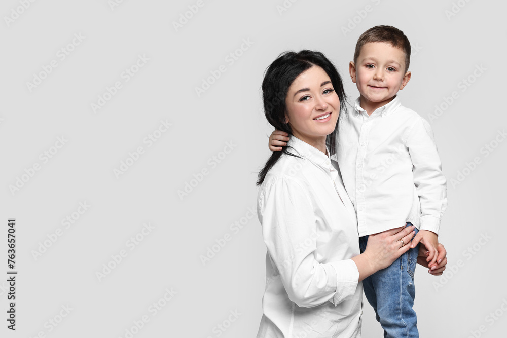 Beautiful mother with little son on white background. Space for text Beautiful mother with little son on white background. Space for text