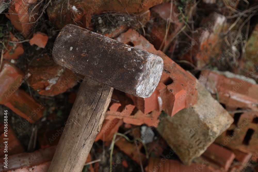 Sledgehammer on pile of broken bricks outdoors, above view Sledgehammer on pile of broken bricks outdoors, above view
