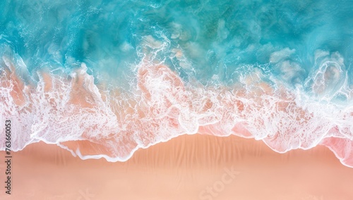 Overhead shot captures the soft foam of waves caressing a sunlit sandy coastline.