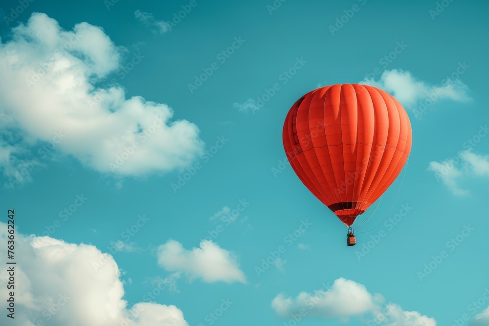 A red hot air balloon is floating in the sky above a blue sky A red hot air balloon is floating in the sky above a blue sky
