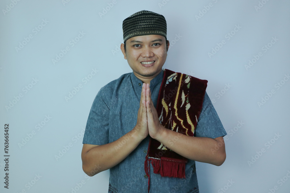 Moslem Asian man smiling when doing greeting pose Moslem Asian man smiling when doing greeting pose