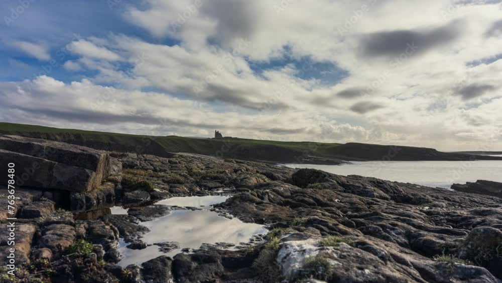 Timelapse of rugged rocky coastline on sunny cloudy day with Classiebawn castle in distance in Mullaghmore Head in county Sligo on the Wild Atlantic Way in Ireland. Timelapse of rugged rocky coastline on sunny cloudy day with Classiebawn castle in distance in Mullaghmore Head in county Sligo on the Wild Atlantic Way in Ireland.