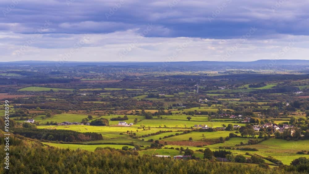 Time lapse of rural farming landscape of local farmhouses with forest and hills during a cloudy day viewed from above Lough Meelagh in county Roscommon in Ireland. Time lapse of rural farming landscape of local farmhouses with forest and hills during a cloudy day viewed from above Lough Meelagh in county Roscommon in Ireland.