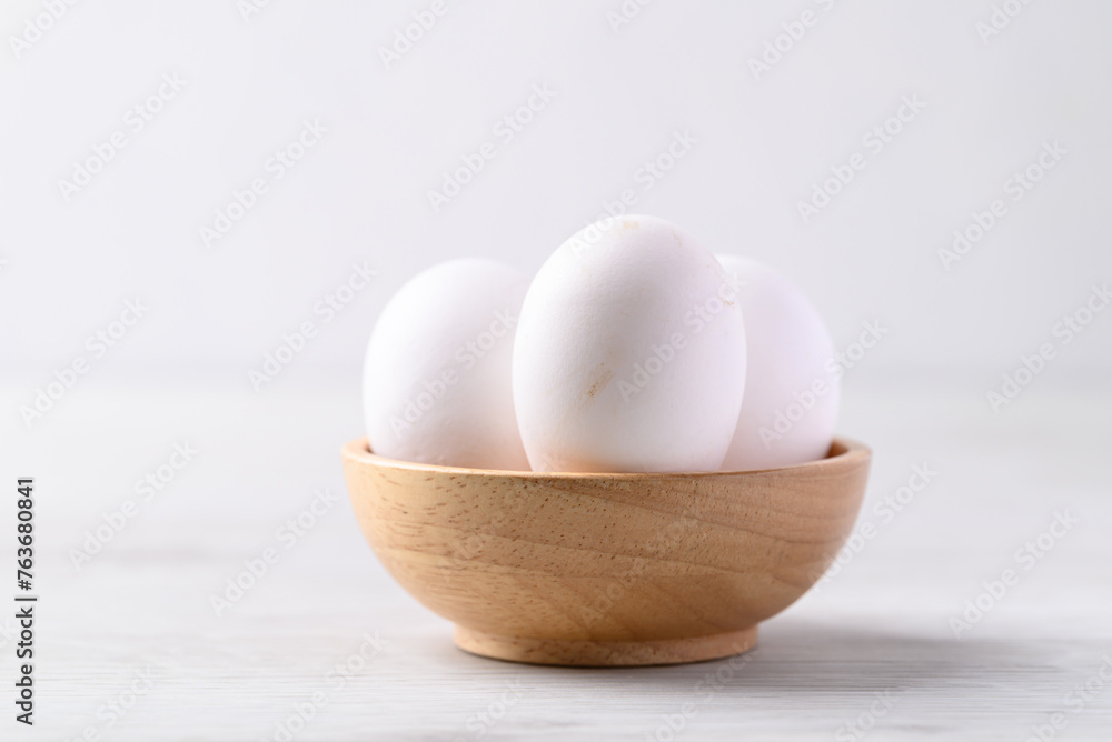 Organic white leghorn egg from free range farm in wooden bowl Organic white leghorn egg from free range farm in wooden bowl