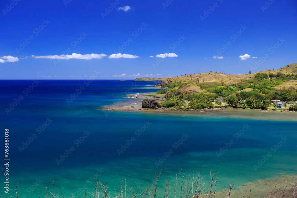 The village of Umatac, along Guam's western coastline, with blue skies and turquoise water The village of Umatac, along Guam's western coastline, with blue skies and turquoise water