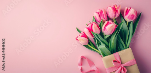 Mother's Day concept. Top view photo of bunch of pink tulips tied with ribbon small giftbox with bow and envelope with postcard on isolated pastel pink background with empty space #763684632