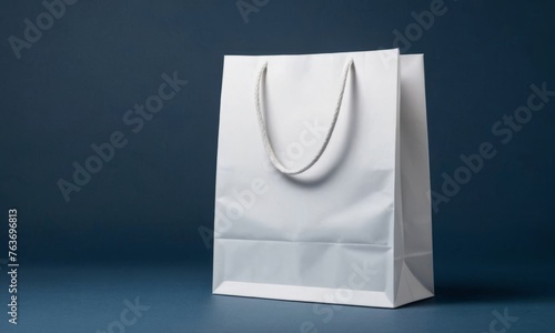 Minimalistic banner with White paper gift bag on a deep blue background with copy space. Concept of sale and shopping