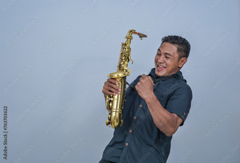 Fototapeta premium A man holding a Saxophone