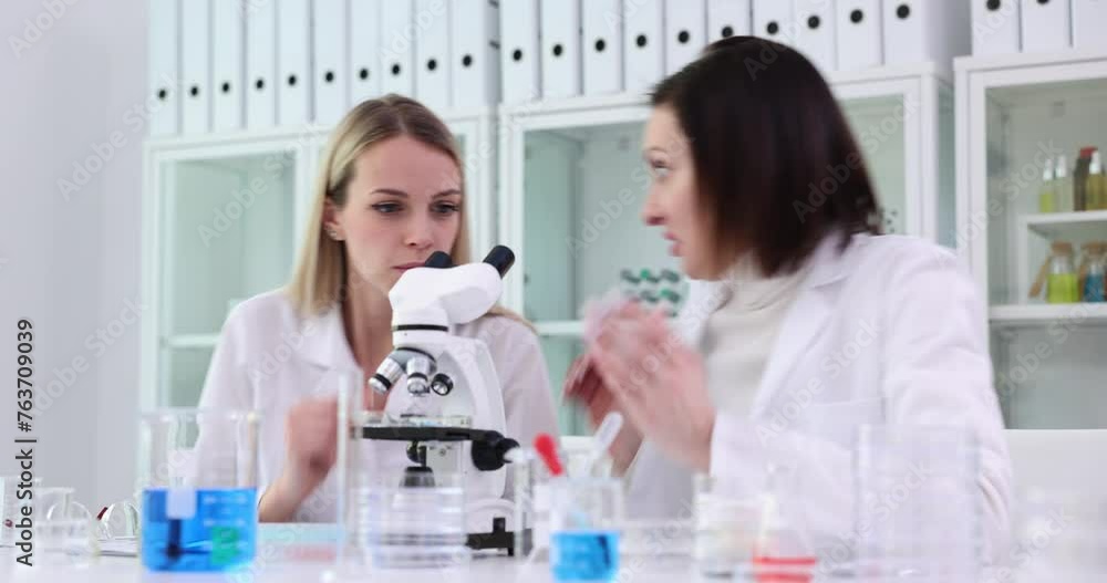 Women scientists observe specimen and react with surprise Women scientists observe specimen and react with surprise
