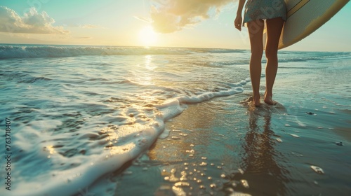 Close up of young woman holding paddleboard walking towards sea during at beach. photo