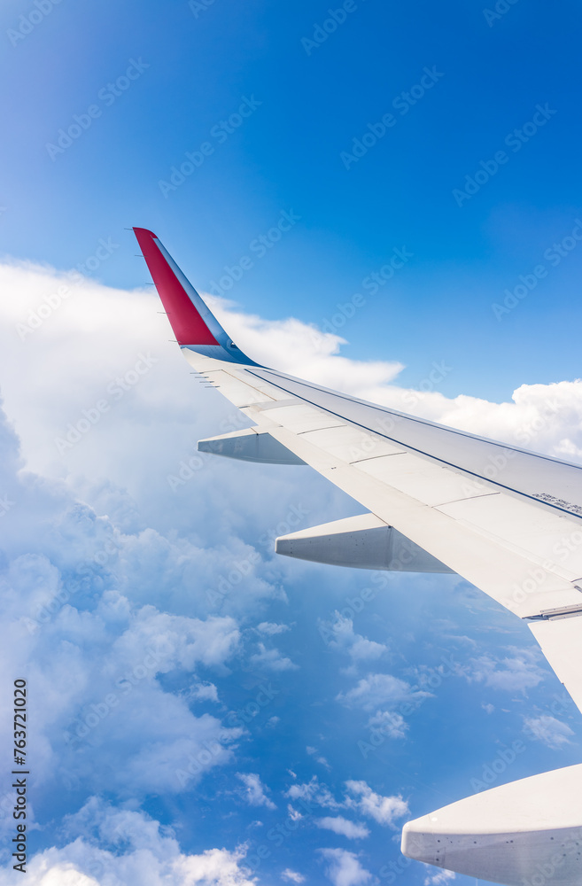 View from the airplane window at a beautiful cloudy sky and the airplane wing View from the airplane window at a beautiful cloudy sky and the airplane wing