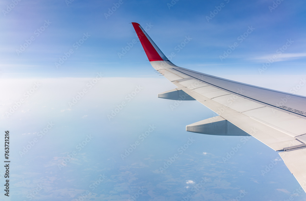 View from the airplane window at a beautiful cloudy sky and the airplane wing