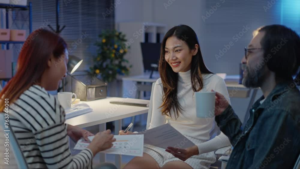 group of Happy young asian business people chatting happily after a night of overtime work in the office.Supervisor chats with employees after working together planning success strategy enjoy teamwork group of Happy young asian business people chatting happily after a night of overtime work in the office.Supervisor chats with employees after working together planning success strategy enjoy teamwork