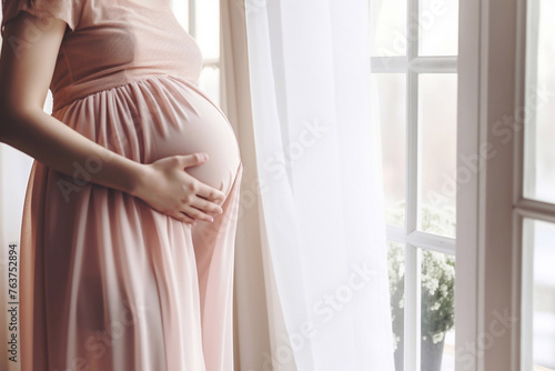Unrecognizable pregnant woman touching baby bump