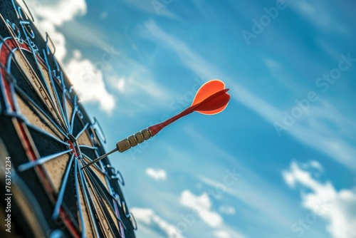 The dart arrow hit the center of the target on the dartboard with a blue sky background, in the style of business success and marketing goal concept. photo