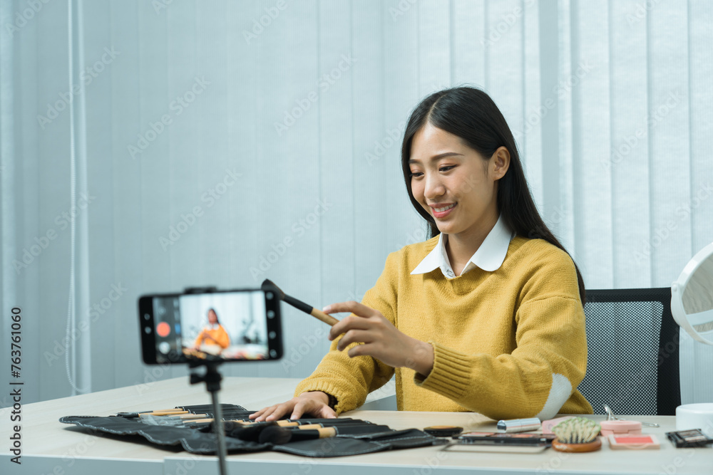 Asian teenage girls doing makeup vlogs and using a video mobile camera to record vlogs and publish them online at home. Asian teenage girls doing makeup vlogs and using a video mobile camera to record vlogs and publish them online at home.