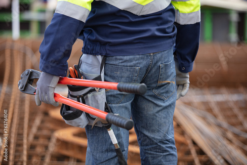 worker holding pliers at construction site