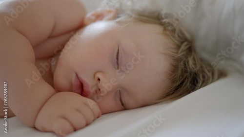 Peaceful baby boy sleeping bed in room. One year-old babyboy sleep home cute little toddler sleeps sweetly in crib sees colorful dream Sleeping baby happy and carefree in bed. Happiness sleep children photo