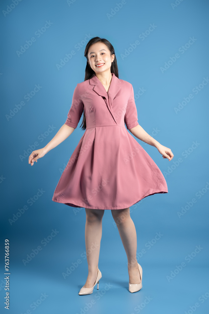 Fototapeta premium Full body image of female businessman posing on a blue background