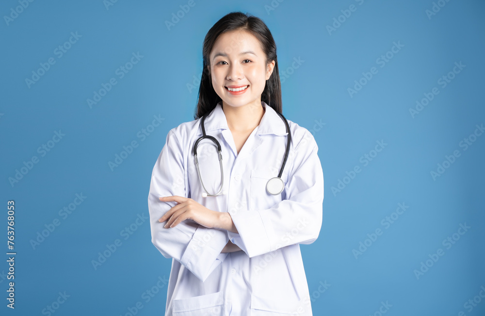 Image of Asian female doctor posing on a blue background Image of Asian female doctor posing on a blue background