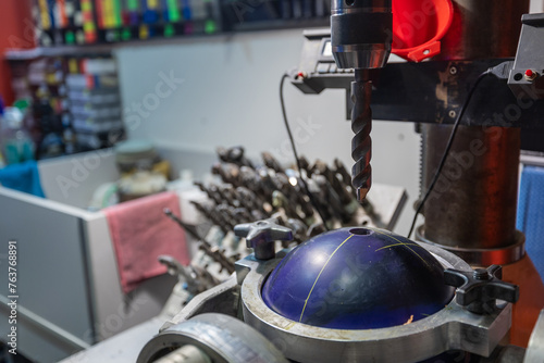 Obraz na płótnie Drilling holes with a drill bit into bowling ball. Preparing bowling ball for a customer, custom holes with special size and diameter into a ball. w salonie