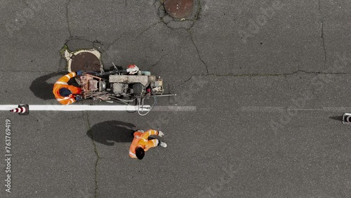 Segnaletica stradale. Verniciatura strisce pedonali e linee di mezzeria.
Vista dall'alto di operai a lavoro sulle strade. photo