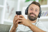 positive guy enjoying favorite song while relaxing at home