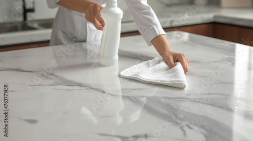 woman's hands are cleaning the kitchen table with a cloth and spray