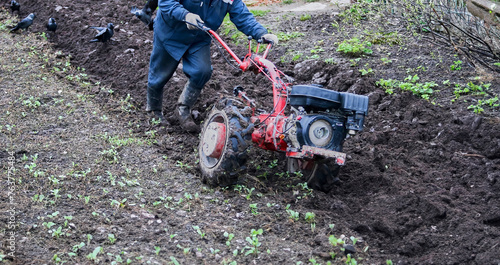 Tractor plowing field in rural area, preparing soil for planting season