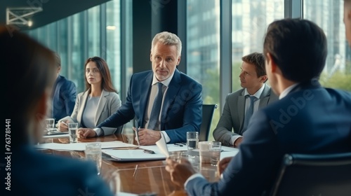 A group of people are sitting around a table in a conference room