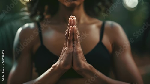 A focused shot of hands clasped together in front of the heart showcasing the surface of the skin and the subtle energy transfer that occurs during yoga poses. photo