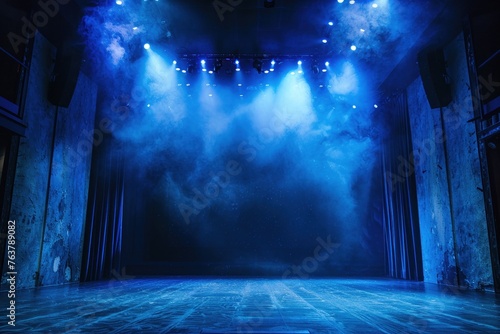An empty stage awaits bathed in dramatic blue spotlighting photo