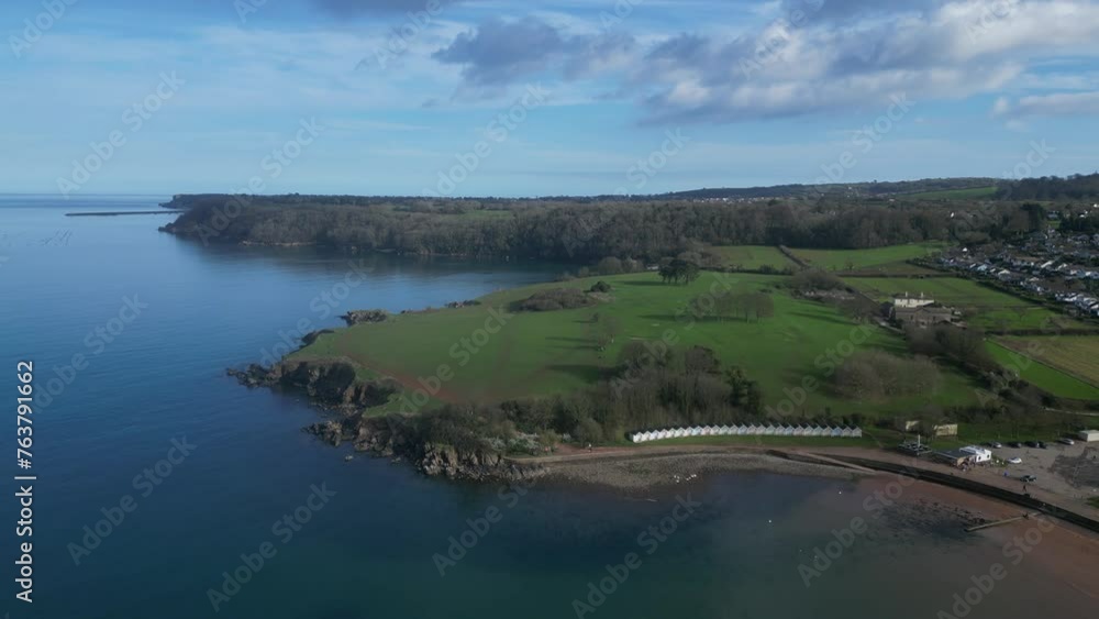 Broadsands, Torbay, South Devon, England: DRONE VIEWS: Tilt up from beach huts; sea; Torbay coastline; sandy beach and houses. Torbay is a popular UK holiday resort (Clip 5). Broadsands, Torbay, South Devon, England: DRONE VIEWS: Tilt up from beach huts; sea; Torbay coastline; sandy beach and houses. Torbay is a popular UK holiday resort (Clip 5).