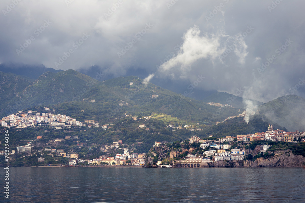 The Amalfi coast. The small harbor of Amalfi village with turquoise sea and colorful houses on the slopes of the coast in foggy weather.
