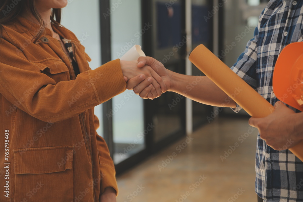 Obraz premium Male and Female Industrial Engineers in Hard Hats Discuss New Project while Using Laptop. They Make Showing Gestures.They Work in a Heavy Industry Manufacturing Factory.
