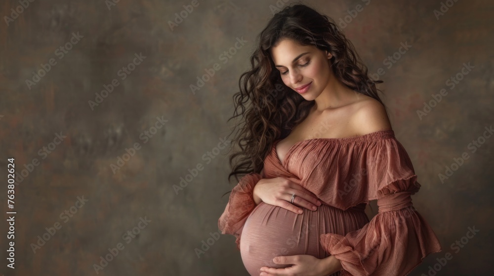 Naklejka premium Young pregnant woman against the dark studio background. Waiting for the birth of a child