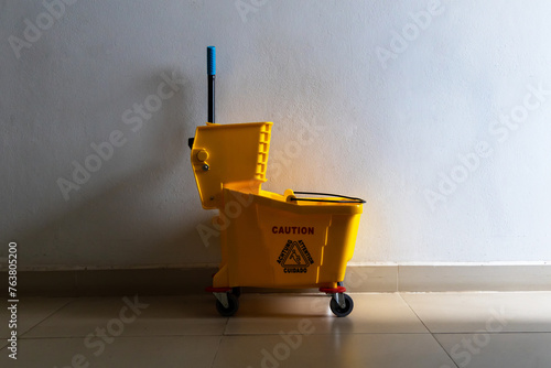 Mop wringer bucket for mopping floor of house or office building equipment for janitor or housekeeper cleaner service. photo