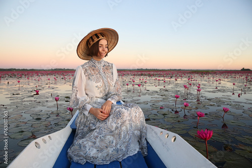 Foto Beautiful woman, fashion girl in hat and lake with red lotuses in Udon Thani, Thailand