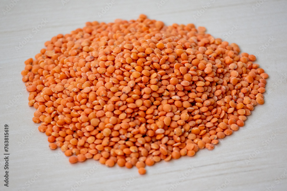 Raw red lentils isolated on a wooden background. Incorporating red lentils into your diet can help you easily meet fiber and protein needs. Raw red lentils isolated on a wooden background. Incorporating red lentils into your diet can help you easily meet fiber and protein needs.