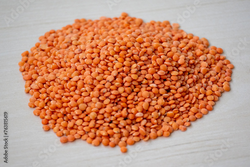Raw red lentils isolated on a wooden background. Incorporating red lentils into your diet can help you easily meet fiber and protein needs.