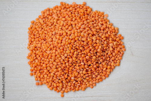 Red lentils or Masoor Dal isolated on a wooden textured background. Incorporating red lentils into your diet can help you easily meet fiber and protein needs. photo